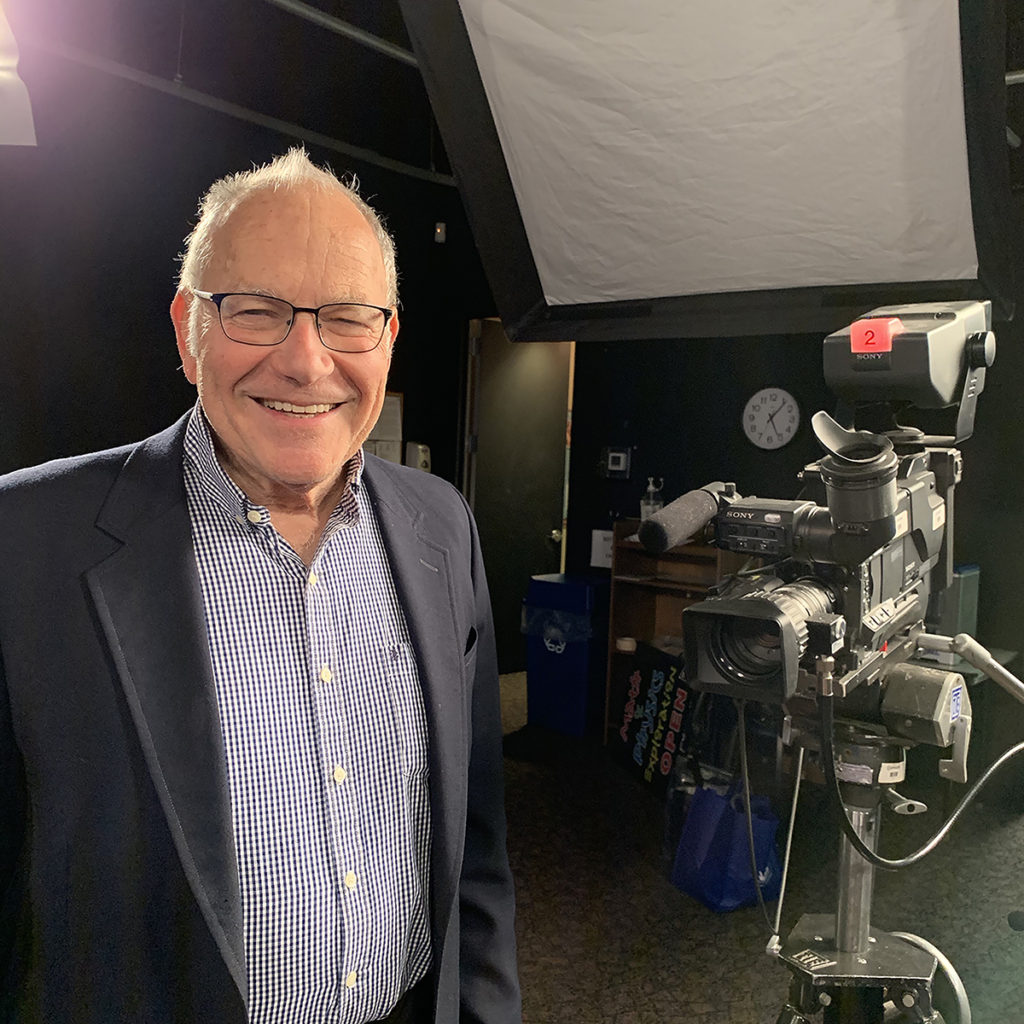 Irvin Miller standing TV studio near camera